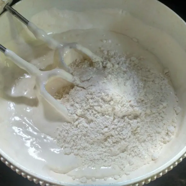 Masukkan tepung terigu dan baking powder, kocok sebentar hingga tercampur rata.
