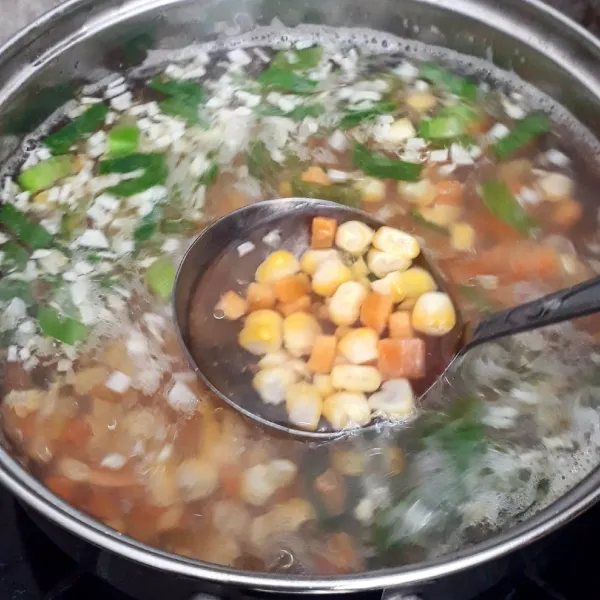 Masukkan wortel, jagung dan daun bawang lalu masak hingga agak layu