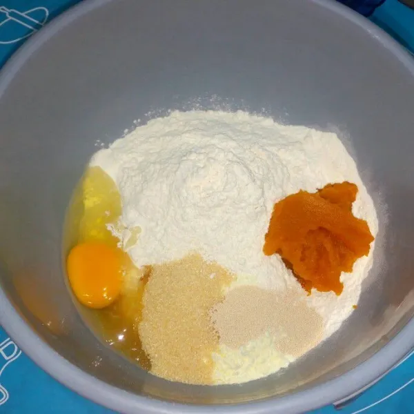 Di wadah campur terigu, labu kuning, gula, telur, susu bubuk, ragi dan vanili tuangi susu cair sedikit demi sedikit uleni sampai setengah kalis