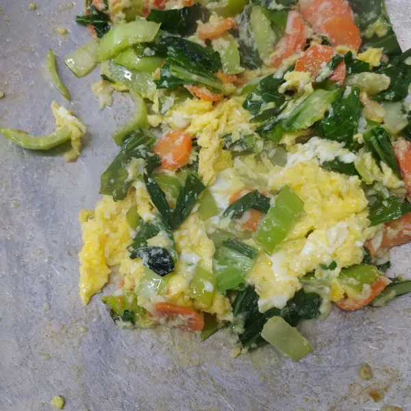 Masukkan kocokan telur ke dalam tumisan sayur. Buat orak-arik telur.