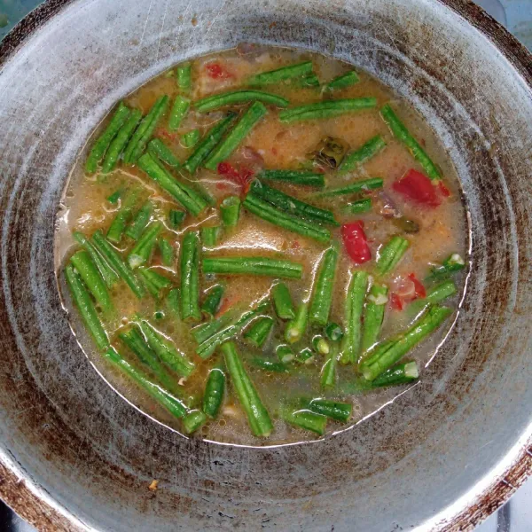 Masukkan kacang panjang dan air. Aduk rata. Masak sampai kacang panjang empuk.