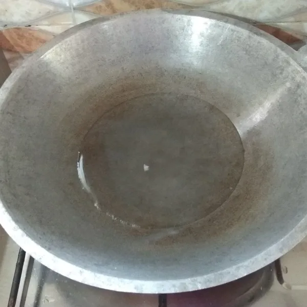 Nyalakan api kompor, masukkan air kelapa ke dalam wajan.