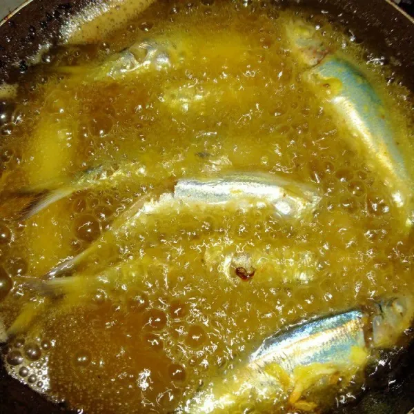 Panaskan minyak. Beri sedikit tepung beras agar ikan tidak lengket. Masukkan ikan goreng hingga matang.