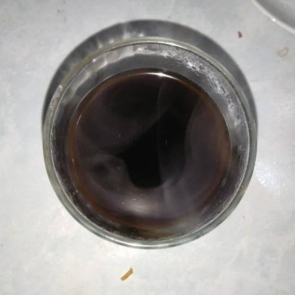 Tuang air ke dalam gelas berisi kopi dan gula. Aduk hingga tercampur rata.