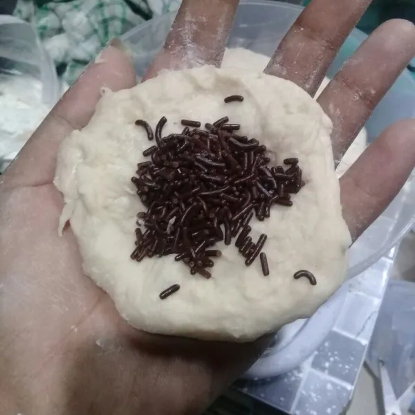 Bagi adonan jadi delapan, ambil satu bagian adonan, pipihkan dan beri isian. Lalu bulatkan.