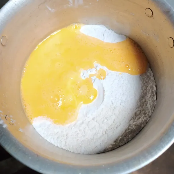 Siapkan wadah, masukkan tepung ketan, tepung terigu, garam halus dan kocokan telur.