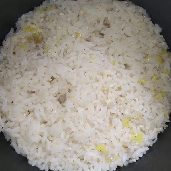 Masukkan beras kedalam panci rice cooker, tambahkan air kaldu sesuai jumlah air untuk menanak nasi, masak nasi hingga matang.
