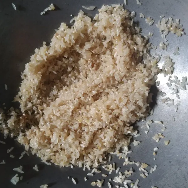 Kecilkan api, masukan beras, bumbui dengan kecap asin, saus tiram, kaldu bubuk dan minyak wijen, aduk rata