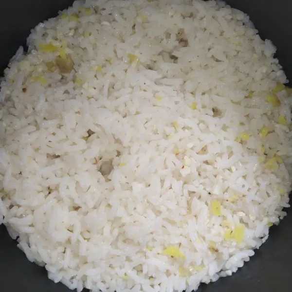 Masukan beras kedalam panci rice cooker, tambahkan air kaldu ayam sesuai jumlah untuk menanak nasi (2 ruas jari) masak hingga nasi matang