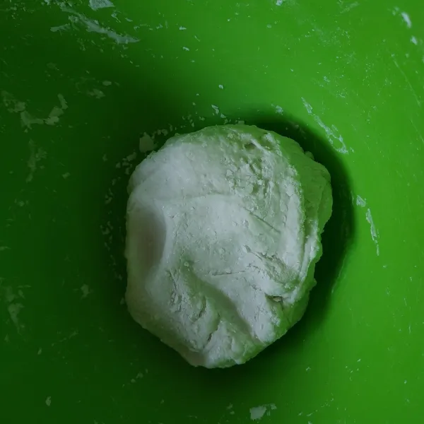 Tuang adonan ke dalam sisa tepung kering, aduk menggunakan sendok, setelah tidak terlalu panas uleni dengan tangan.