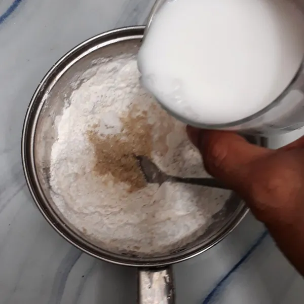 Masukkan tepung beras, tepung hunkwe, tepung tapioka, gula pasir dan garam ke dalam panci lalu aduk rata. Tuangkan santan lalu aduk rata.