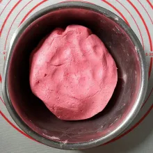 Tuang santan hangat kecampuran tepung ketan dan garam sedikit demi sedikit sambil diulen. Santan tidak harus habis, asal adonan sudah cukup lembab dan kalis hentikan penuangan santan. Bubuhi pewarna merah secukupnya, ulen rata.