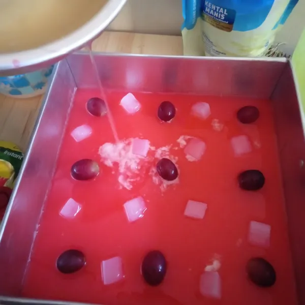 Tata anggur dan nata decoco. tuang puding bening sedikit demi sedikit supata tatanan tidak rusak. masukkan kulkas.