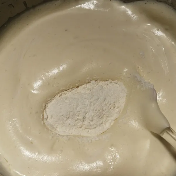 Tuang bahan kering tepung terigu, baking powder dan garam yang sebelumnya sudah di ayak terlebih dahulu, secara bertahap. Dengan cara aduk lipat.