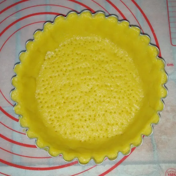 Gilas adonan hingga agak tipis. Masukkan ke dalam cetakan kue pie. Tusuk-tusuk bagian dasar adonan dengan garpu.