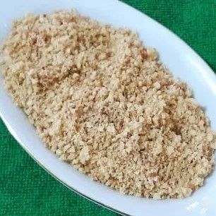 Taruh serbuk kerupuk udang ke dalam piring saji. Serbuk koya siap digunakan untuk melengkapi aneka soto.