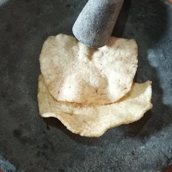 Siapkan ulekan. Masukkan kerupuk udang ke dalam ulekan.