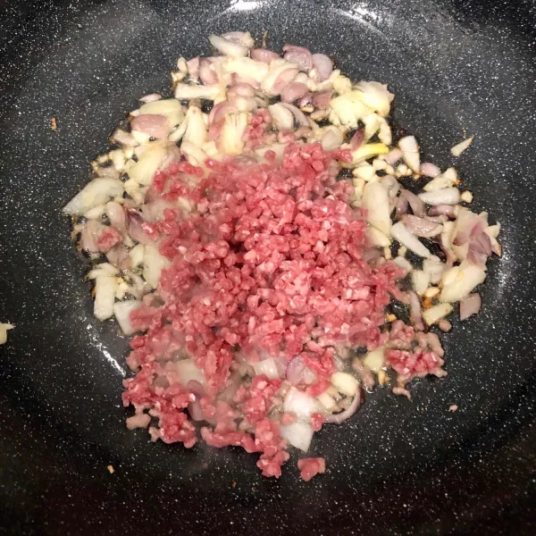 Masukkan daging cincang, kecap asin, kaldu bubuk dan merica lalu tumis hingga harum.