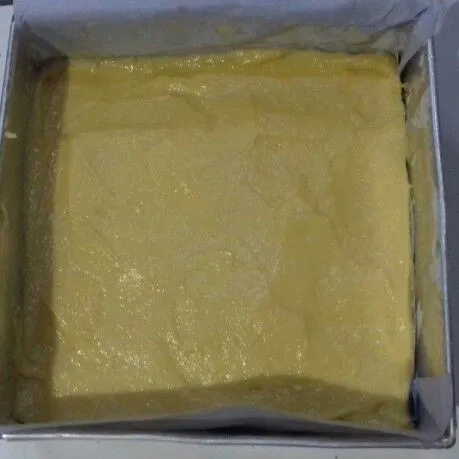 Siapkan loyang disemir margarin dan dialas kertas roti. Semir margarin lagi dan baluri tepung. Masukan adonan. Ratakan hentak perlahan.