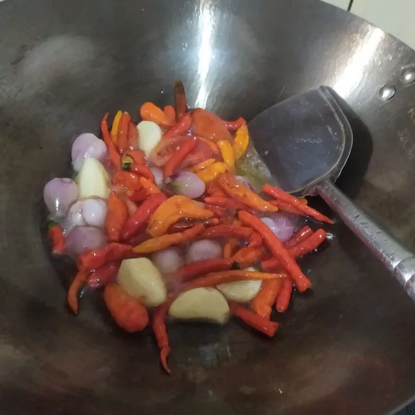Panaskan minyak, goreng bawang, cabai dan tomat hingga layu