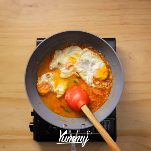 Tuangkan air secukupnya, kemudian masukkan telur ceplok, aduk rata. Masak hingga bumbu menyerap, koreksi rasa.