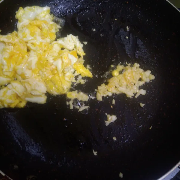 Pinggirkan telur kemudian masukkan bawang putih, tumis hingga harum.