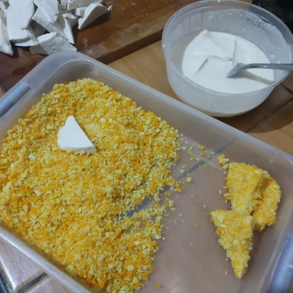 Celupkan irisan tahu dalam adonan tepung, lalu gulingkan dan balut dengan tepung panir. Lakukan sampai tahu habis.