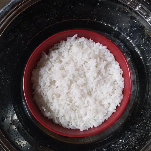 Siapkan mangkuk tahan panas, masukkan tumis jamur di dasar mangkuk, kemudian tambahkan nasi hingga hampir penuh. Kukus selama 20 menit, nasi tim jamur tiram siap disantap
