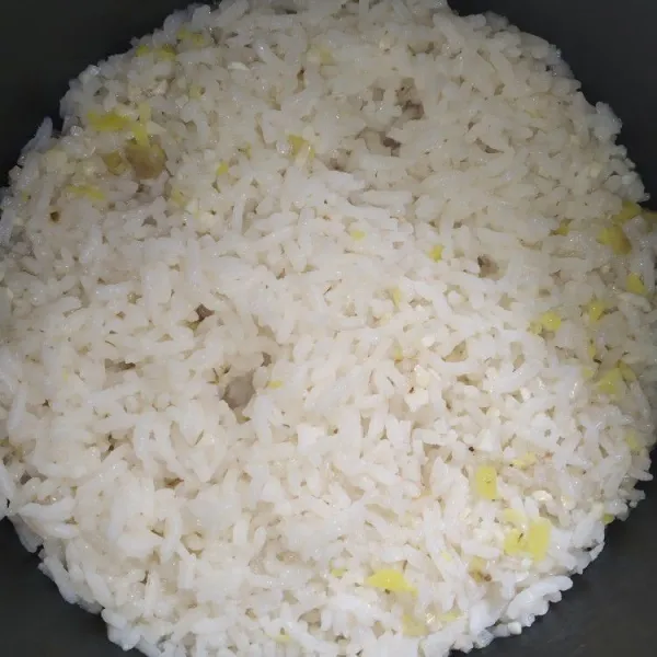 Masukkan beras ke dalam panci rice cooker. Tambahkan air kaldu ayam setinggi 2 ruas jari (seperti menanak nasi pada umumnya), masak nasi hingga matang