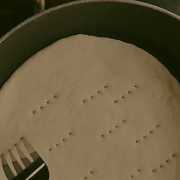 Masak adonan pizza di teflon yang sudah diberi minyak dengan api kecil. Lalu tusuk-tusuk dengan garpu.