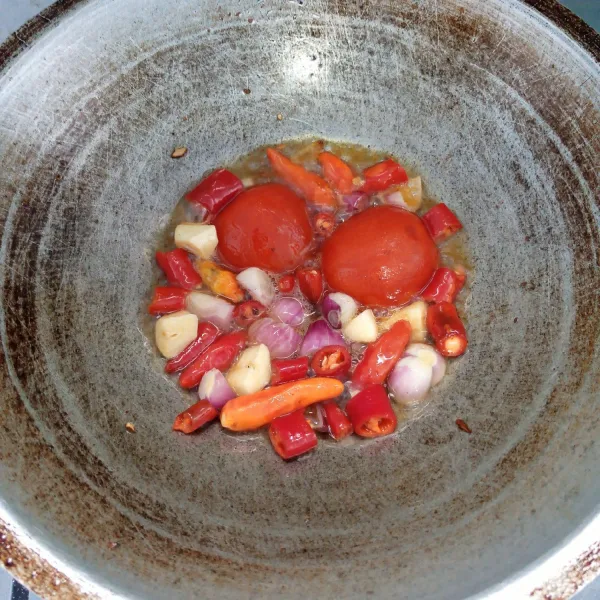 Goreng bawang merah, bawang putih, cabai merah, cabai rawit, dan tomat sampai layu.