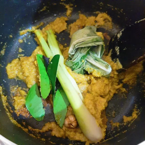 Haluskan bawang putih, bawang merah, jahe, kunyit, dan lengkuas. Panaskan 3 sendok makan minyak dan tumis bumbu halus sampai harum. Masukkan batang serai, daun kunyit, asam kandis, daun jeruk, dan kapulaga. Tumis sampai harum.
