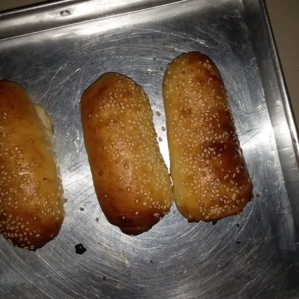 Masukan adonan hotdog ke dalam oven. Panggang selama 10 menit di rak tengah lalu pindahkan ke rak atas selama 10 menit. Setelah berwarna kecoklatan, keluarkan dari oven. Langsung oleskan butter.
