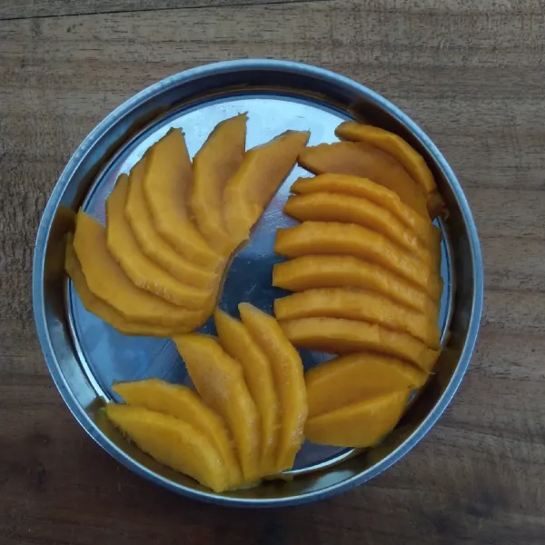 Kupas buah mangga lalu potong tipis.