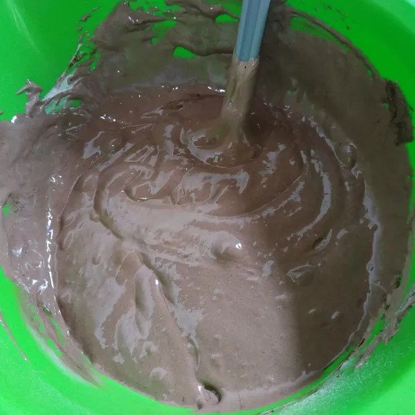 Selanjutnya masukkan campuran coklat yang telah dilelehkan, aduk dan balik dengan spatula hingga rata.
