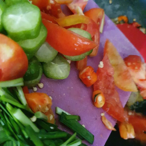 Masukkan irisan tomat, belimbing sayur. Masak sebentar. Tambahkan daun kucai. Aduk sebentar. Angkat.