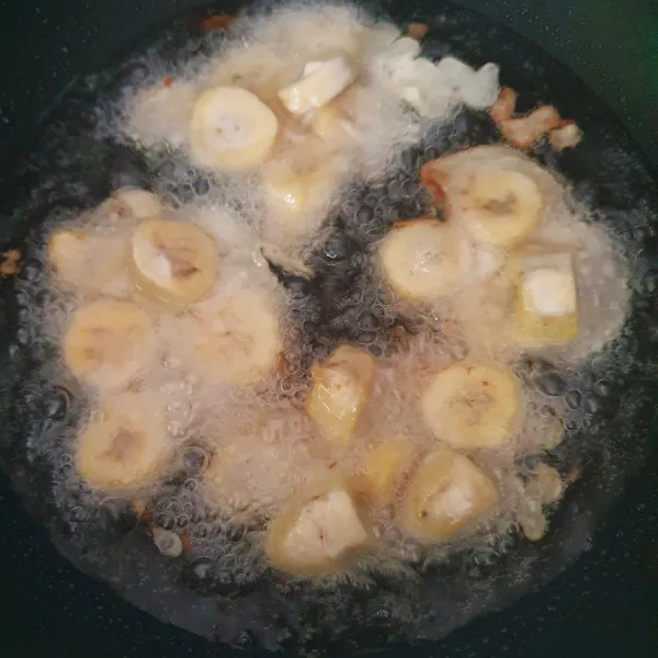 Masukkan potongan pisang ke dalam adonan, lalu goreng ke dalam minyak panas.