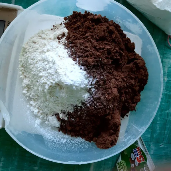 Dalam wadah besar ayak tepung, bubuk coklat, susu bubuk dan baking powder.