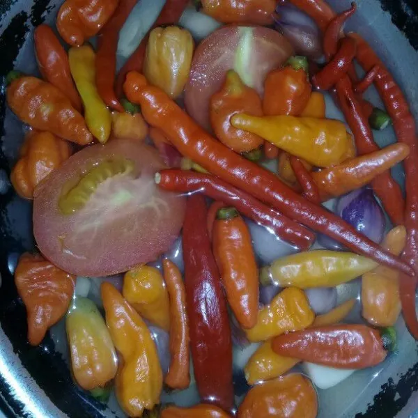 Lalu cabe merah, cabe rawit, bawang merah, bawang putih dan tomat direbus sebentar sampai layu, kemudian haluskan.