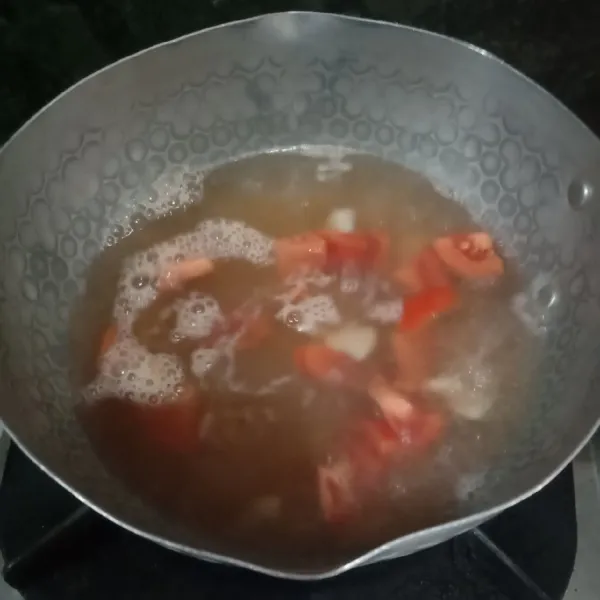 Didihkan air kaldu, lalu masukkan bawang putih, tomat dan minyak wijen. Aduk rata.