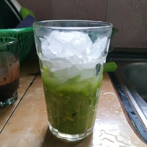 Siapkan gelas, tuang alpukat lalu tambahkan es batu di atasnya.