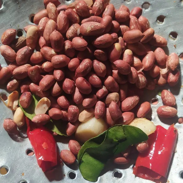 Goreng kacang tanah hingga matang. Lalu goreng cabai merah, bawang putih, dan daun jeruk.