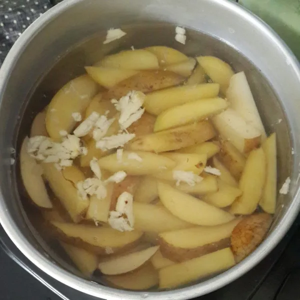 Didihkan air bersama garam dan bawang putih, rebus kentang setengah matang, angkat dan tiriskan