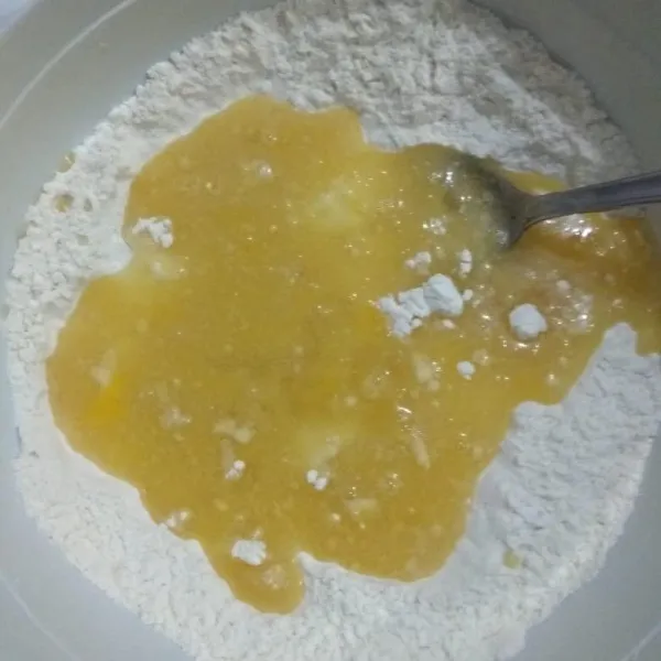 Masukkan campuran bahan biang ke dalam tepung, aduk rata dengan sendok. Ulek sebentar dengan tangan hingga agak kalis
