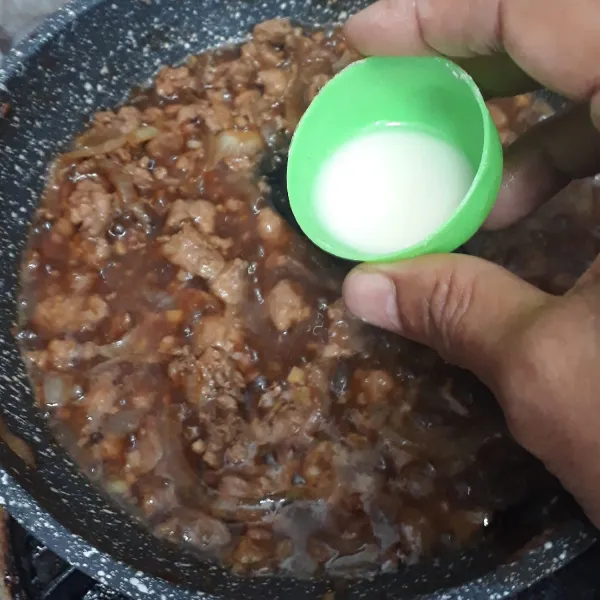 Tuang larutan tepung tapioka lalu aduk rata. Masak beberapa saat hingga agak mengental.