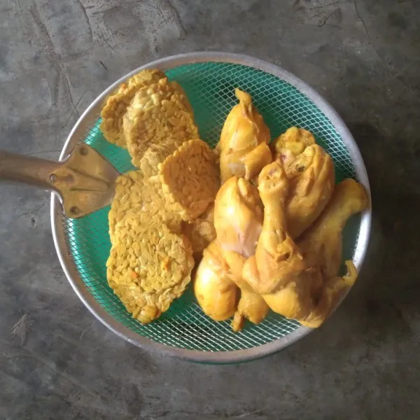 Tiriskan ayam dan tempe setelah matang.