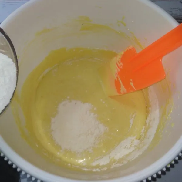 Tambahkan susu bubuk, aduk hingga rata, kemudian masukkan tepung terigu sedikit demi sedikit sambil diaduk dengan spatula hingga adonan kalis dan bisa dibentuk