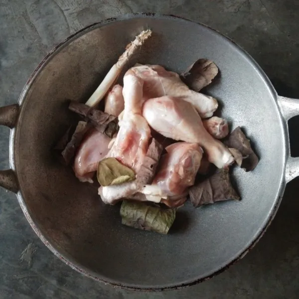 Masukkan ayam di wajan (lebih mudah mengungkep dengan wajan karena lebih cepat air berkurang dari pada panci sehingga bumbu cepat diserap ayam). Tambahkan daun salam, daun jeruk, kayu manis, sereh.