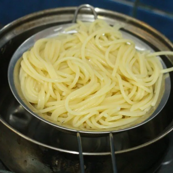 Rebus spaghetti sesuai instruksi, tiriskan.