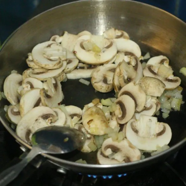 Masukkan jamur yang sudah dicuci dan iris, aduk sampai layu.